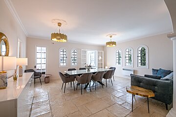 A dining room with a table and chairs and a couch