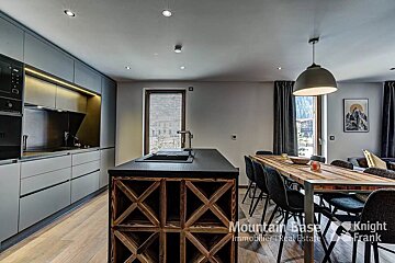 A kitchen with a wooden table and chairs and a sign that says mountain base