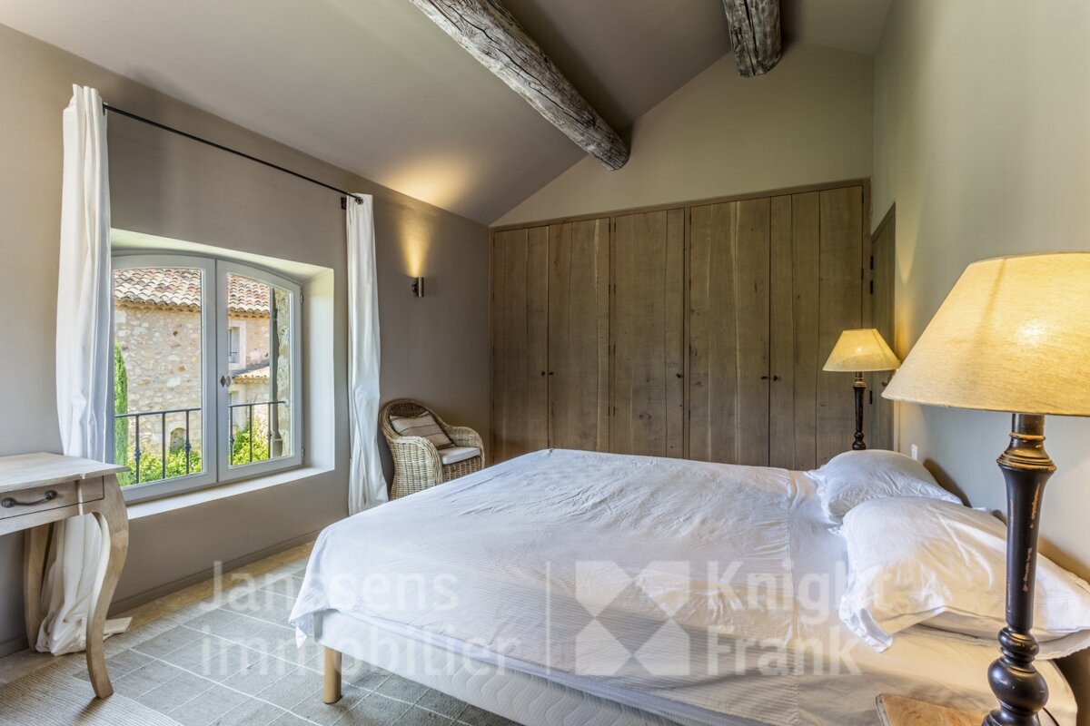 A bedroom with a large bed and a lamp and a sign that says knight frank