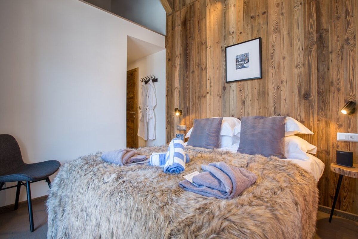 A bedroom with a picture on the wall above the bed