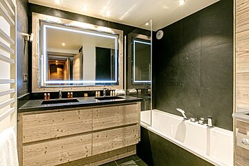 A bathroom with two sinks and a large mirror