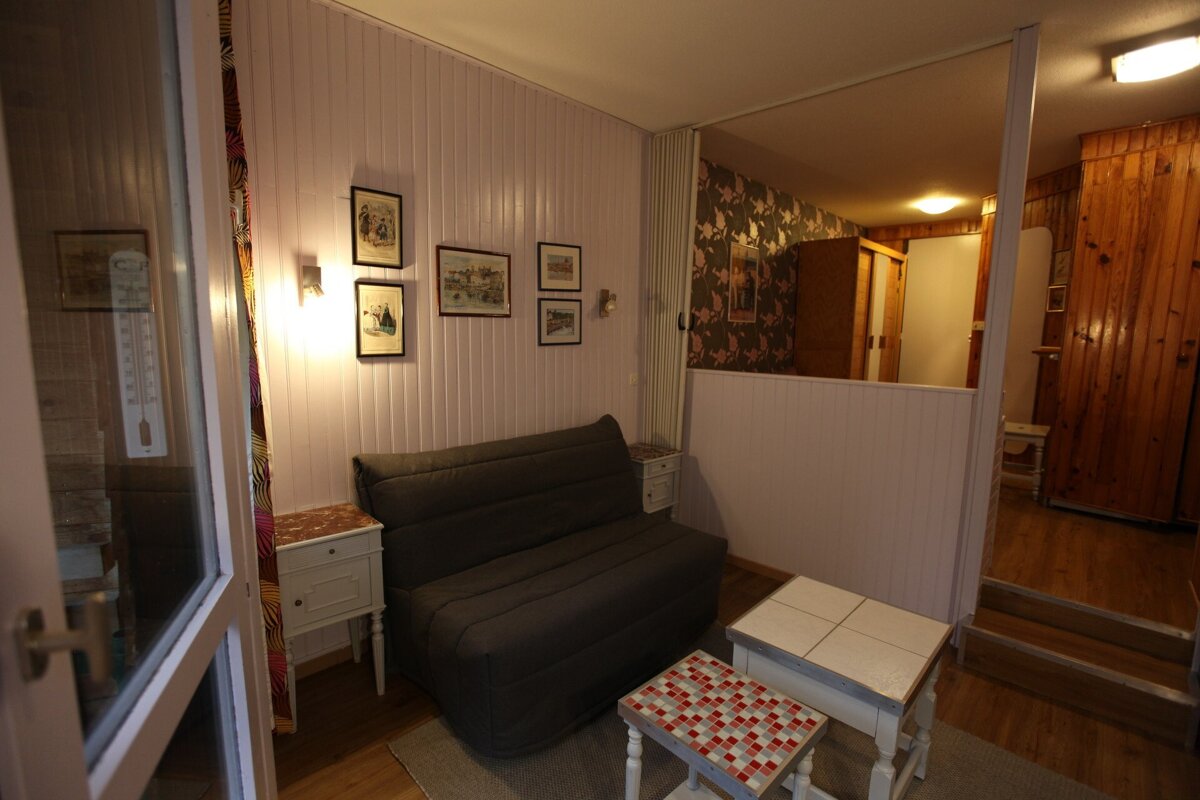 A room with a couch and a thermometer on the wall