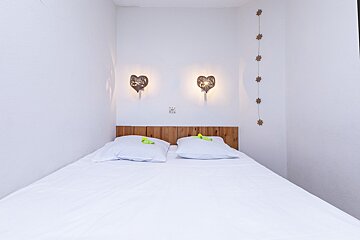 A bed with two pillows and a wooden headboard