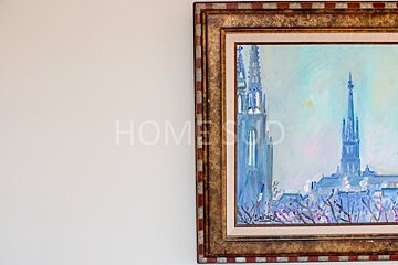 A framed painting on a white wall with the word home on it