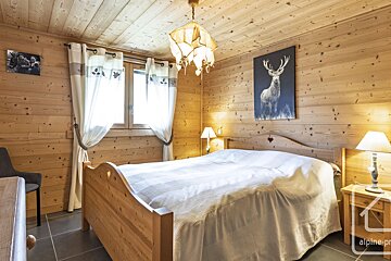 A bedroom with a painting of a deer on the wall