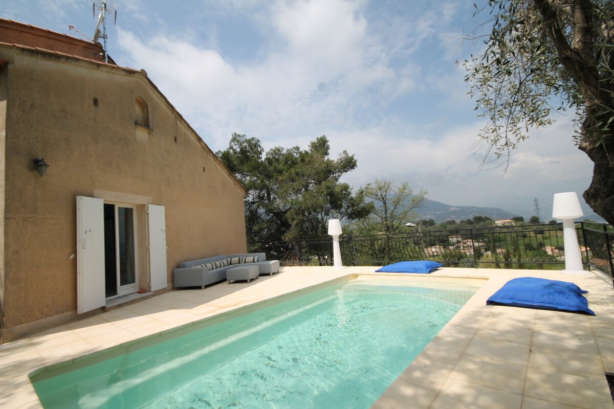 A house with a swimming pool in front of it