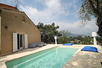 A house with a swimming pool in front of it