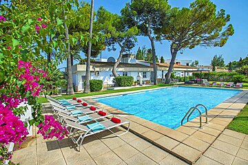 A large swimming pool with a house in the background