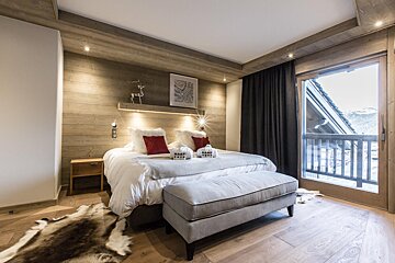 A bedroom with a large bed and a window