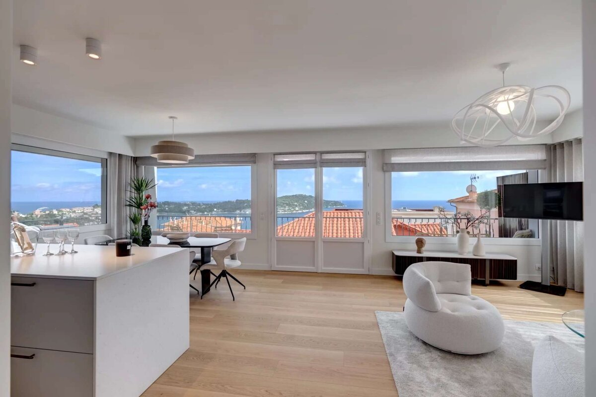 A living room with a view of the ocean and mountains