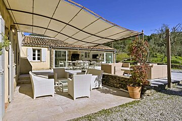 A patio with chairs and tables under an awning