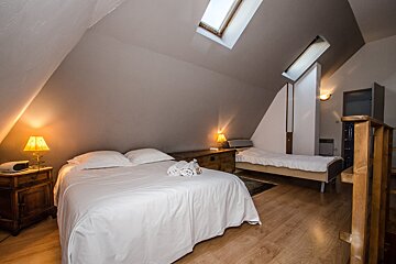 A bedroom with a large bed and a smaller bed