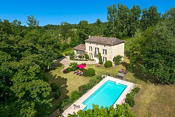 An aerial view of a house with a large swimming pool