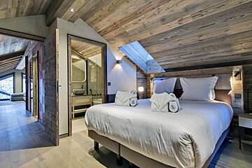 A bedroom with a large bed and a bathroom