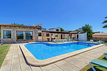A large swimming pool in front of a house