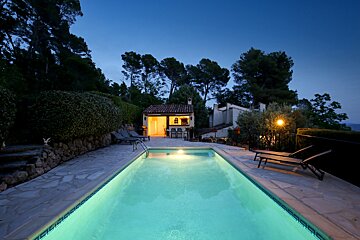 A large swimming pool with a house in the background