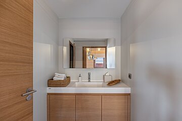 A bathroom with a sink a mirror and a basket of towels