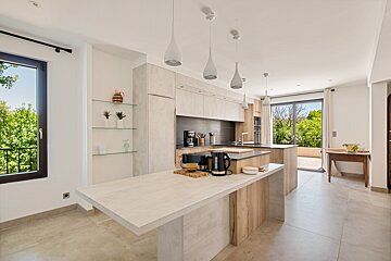 A kitchen with a large island and a sliding glass door
