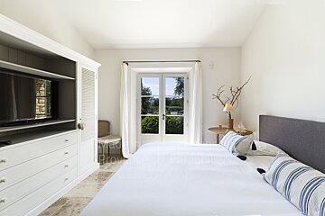 A bedroom with a large bed and a flat screen tv