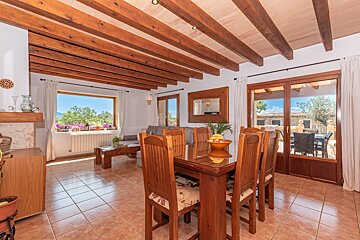 A dining room table with a bowl of fruit on it