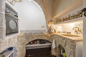 A kitchen with a stove top oven and a sink