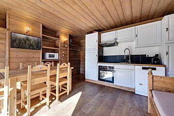 A kitchen with white cabinets and a wooden table and chairs