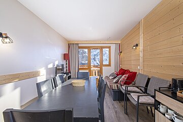 A dining room with a table and chairs and a couch