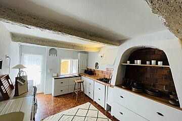 A kitchen with white cabinets and a rug on the floor