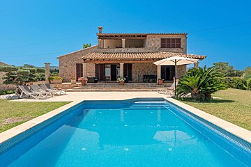 A large house with a swimming pool in front of it