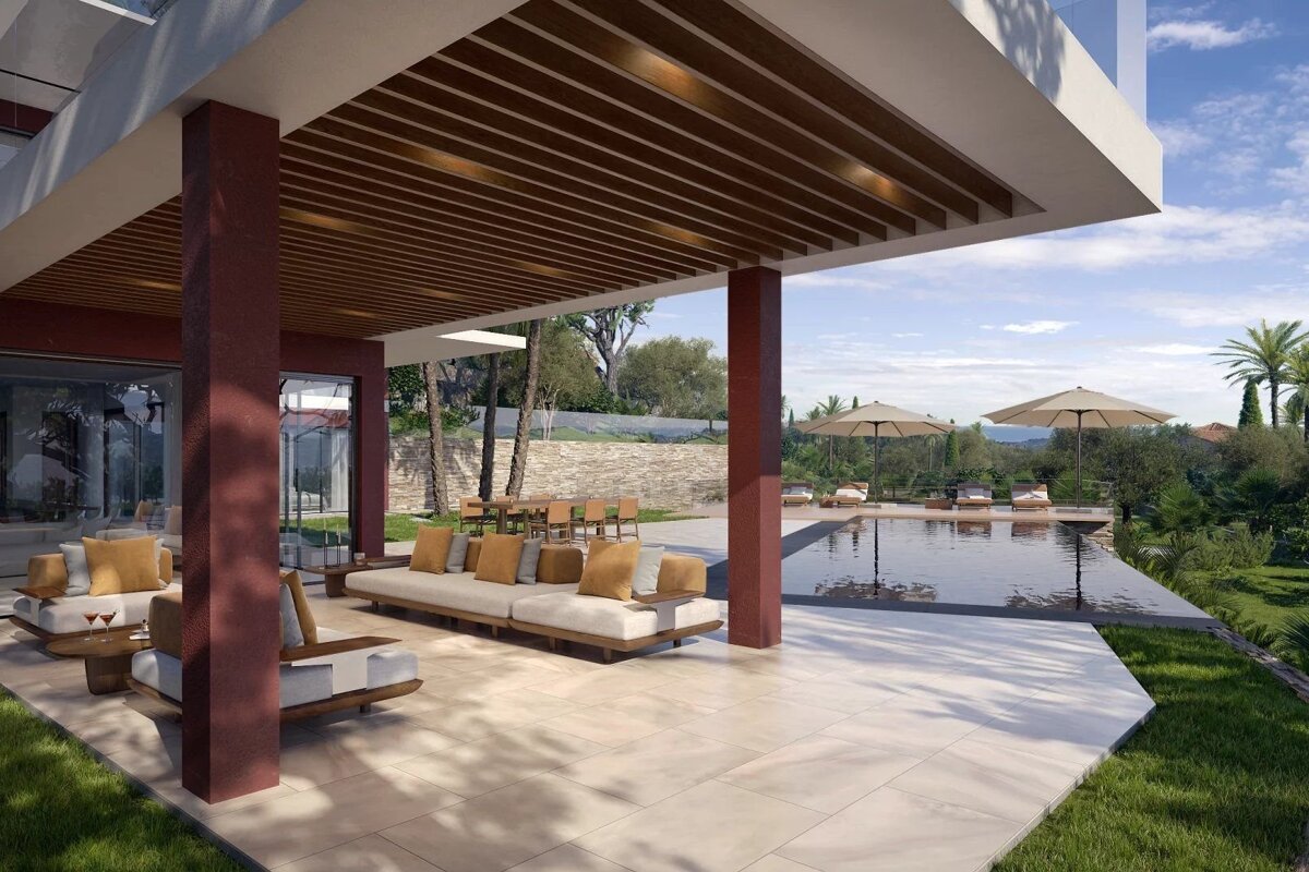 Luxury modern patio with lounge seating under a wooden pergola, overlooking a sparkling swimming pool and a lush green landscape.
