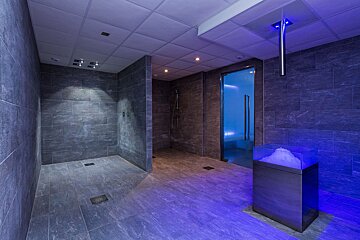 A bathroom with a shower and a glass door