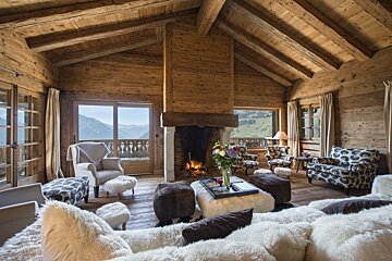 A living room with a fireplace and a view of the mountains