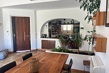 A dining room with a wooden table and chairs and the word home on the wall