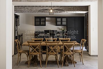 A kitchen with a table and chairs and the words janssens knight frank on the wall