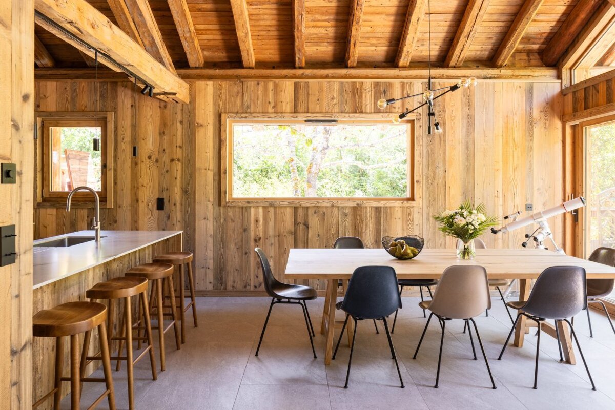 A dining room with a table and chairs and a telescope