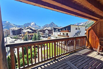 A balcony with a view of a city and mountains