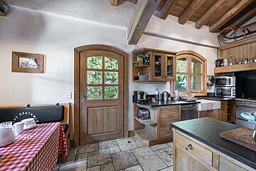 A kitchen with a red and white checkered table cloth