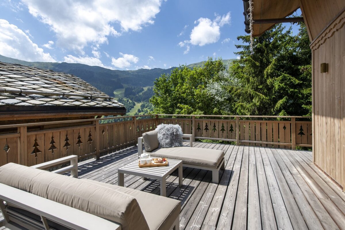 A balcony with a view of the mountains and trees