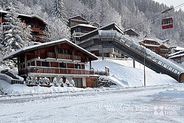 A ski lift is going up a snow covered hill