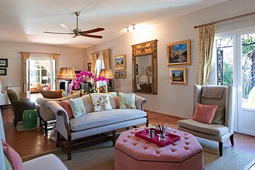 A living room with a white couch and pink ottoman