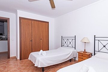 A bedroom with two beds and a ceiling fan