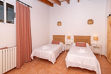 A bedroom with two beds and two lamps