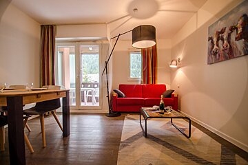 A living room with a red couch and a table