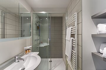 A bathroom with a sink and a walk in shower