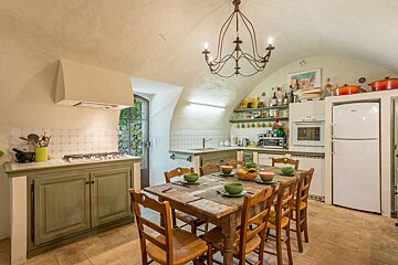 A kitchen with a table and chairs and a whirlpool refrigerator