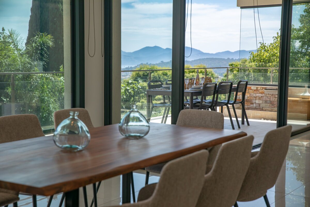 A dining room table with a view of mountains in the background