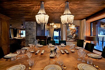 A dining room table is set with plates and glasses