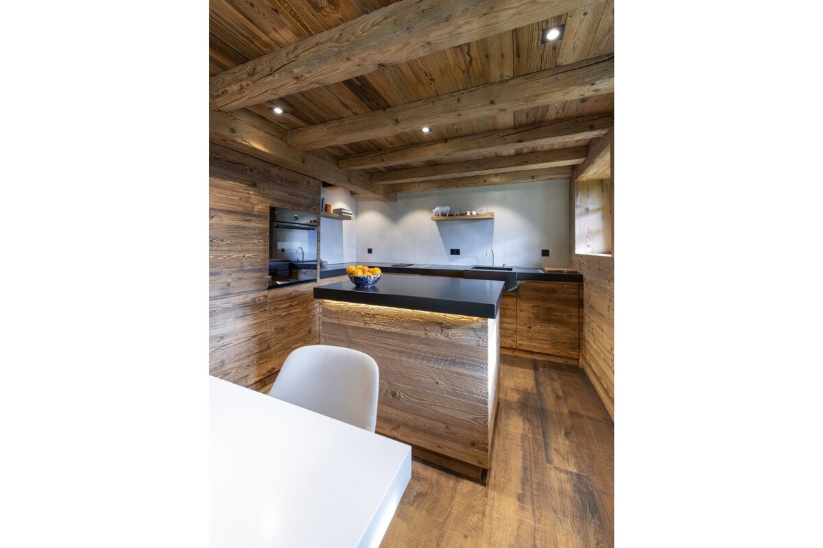 A kitchen with wooden cabinets and a black counter top