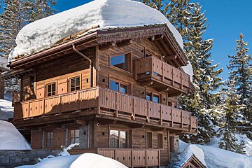 A large wooden house with snow on the roof