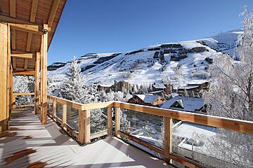 A balcony with a view of a snowy mountain town